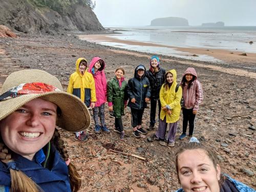 W.I.S.E Camp – Palaeontologist for a Weekend. Girls on the beach in rain gear.