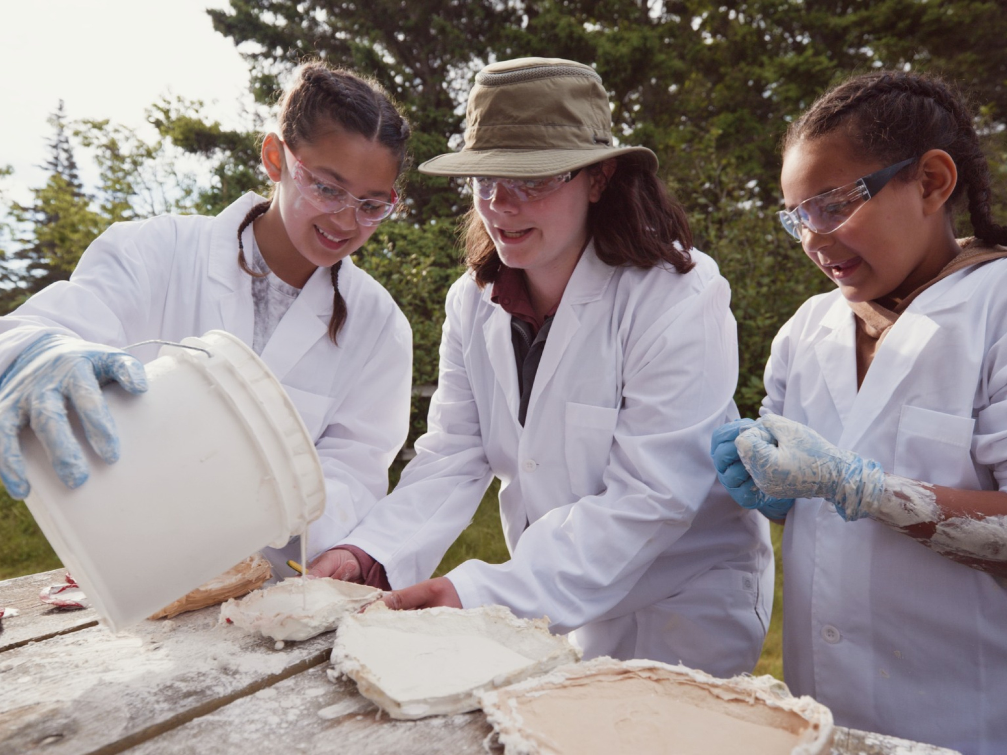 Two girls learning from a female Paleontologist.