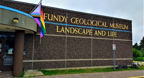Exterior of the Fundy Geological Museum with the Pride Flag flying.